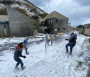 Four expeditioners engaging in a snowball fight in the middle of the station.