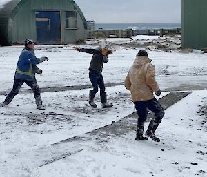 Three expeditioners in the middle of a snowball fight. This time George has found Sara's face with a snowball.