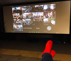 Watching large screen, red socks in foreground