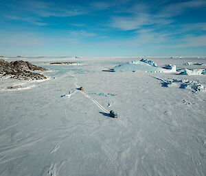 Aerial view of ice and mountains with two haggs on the ice