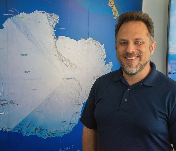 Dr Kool standing in front of an Antarctic map.