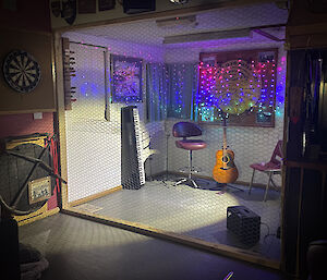 Stage with chicken wire wall in front and fairy lights on back wall