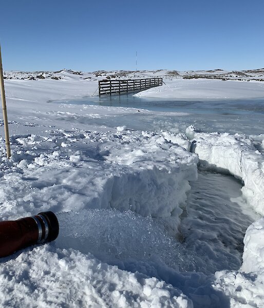 Water flowing from a hose in to the icy water below