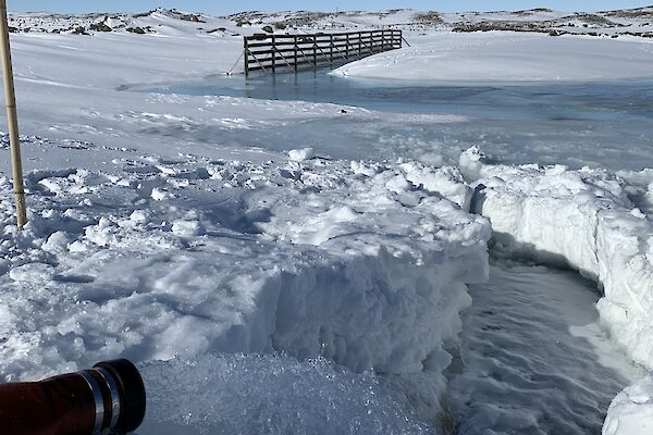 Water flowing from a hose in to the icy water below