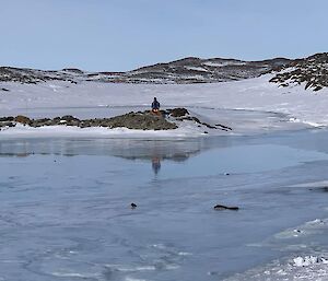 A person watching the tarn fill