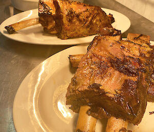 Two big plates of sticky beef ribs and two bowls of stuffed capsicums