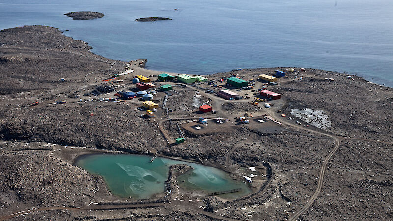 Aerial view of green-coloured tarn behind Davis station buildings.