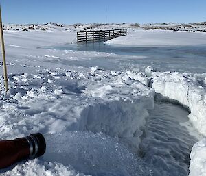 Fresh seawater gushing out of a pipe into the ice-covered tarn.