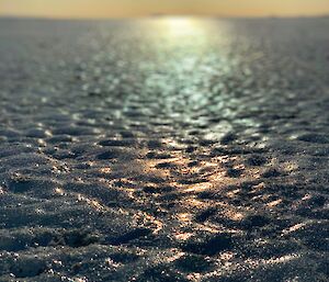 A large sheet of frozen ocean lit by the sun