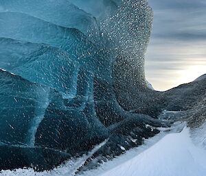 A jade coloured iceberg rising up out of the snow