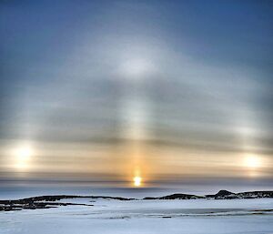 A frozen landscape with a sun halo in the sky