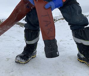 An expeditioner holds an empty hose