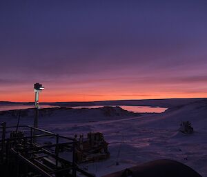 A winter sunrise with upper fuel farm equipment in foreground