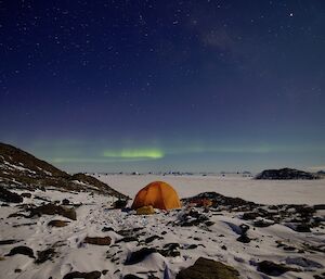 A tent in the snow under the Aurora Australis.