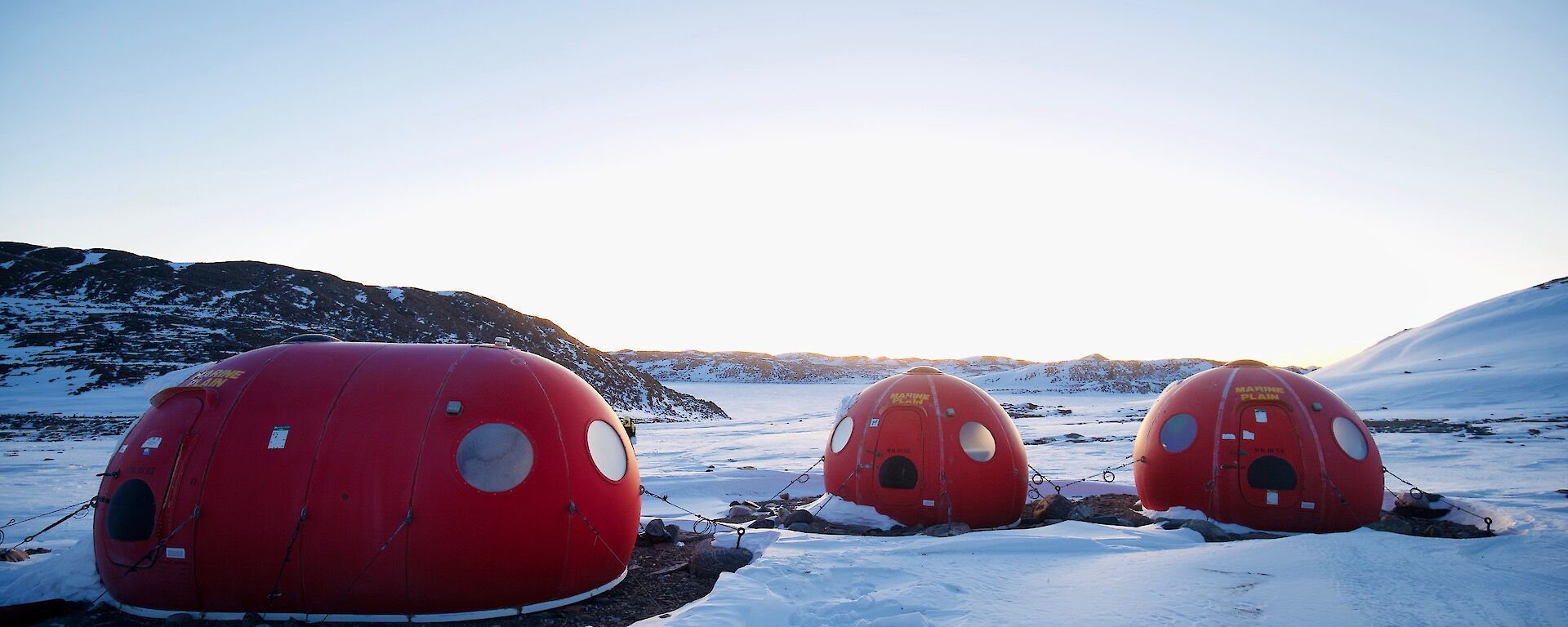 Three round red caravans in the snow