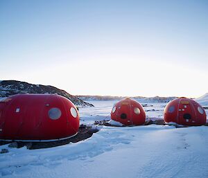 Three round red caravans in the snow
