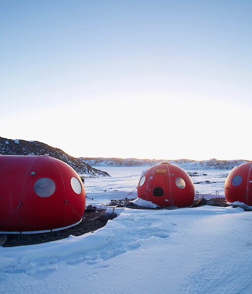 Three round red caravans in the snow