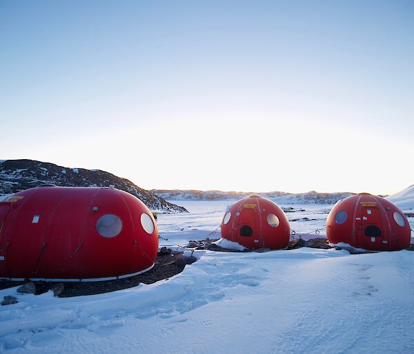 Three round red caravans in the snow