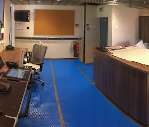 Desks, computer monitors, phones in the operations space on the bridge.