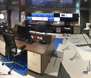 Computer monitors, desks and chairs in the science operations room on the ship.
