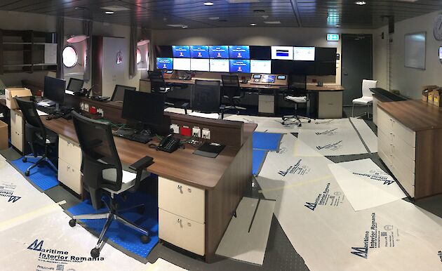 Computer monitors, desks and chairs in the science operations room on the ship.