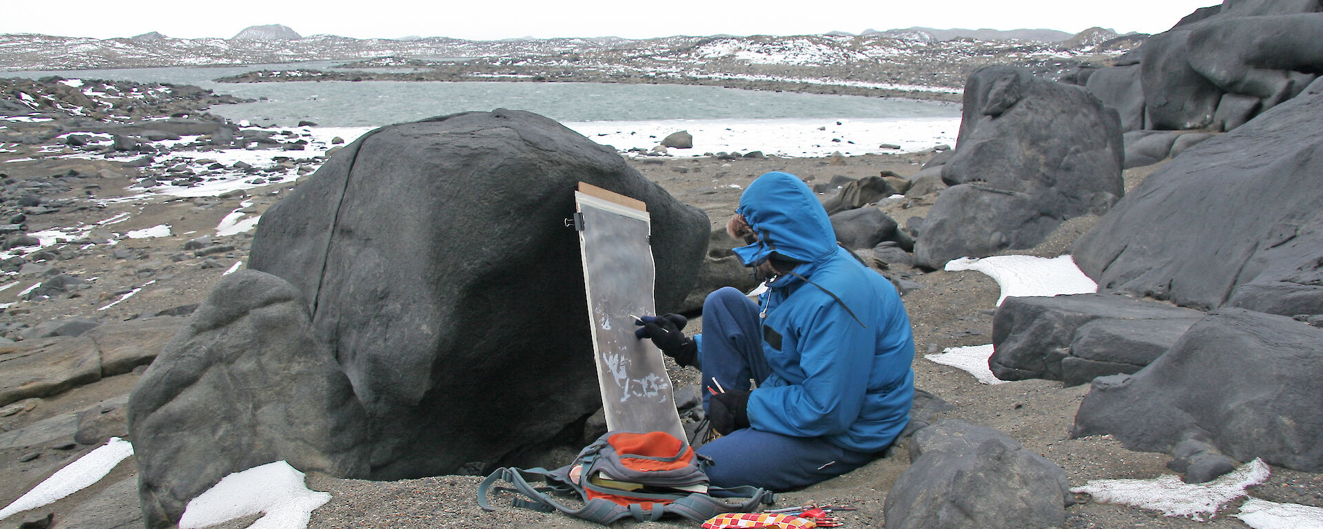 Expeditioner painting on canvas, outdoors.