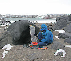 Expeditioner painting on canvas, outdoors.