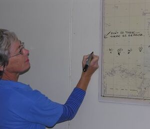 Expeditioner standing near a map on the wall