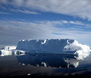Iceberg reflected in mirror-like ocean