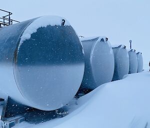 A man stands next to large fuel tanks at the Aerodrome