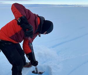 A man shovels snow at the Wilkins runway site