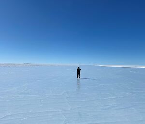 A man stands on the surface of the Wilkins runway