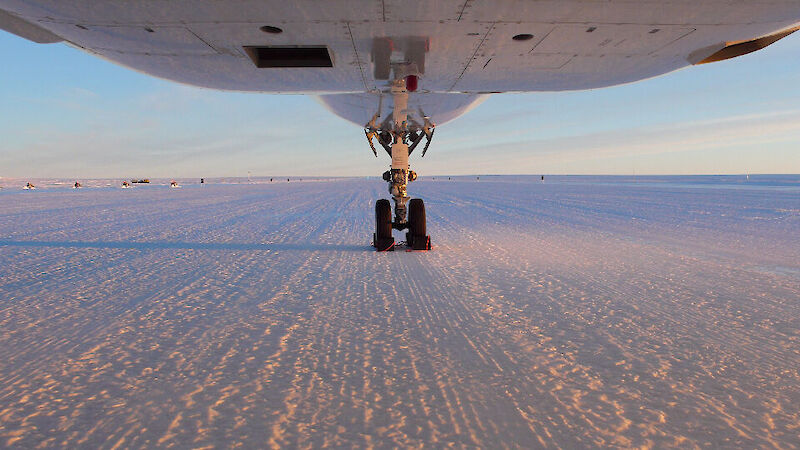 underside of a jet plane on an ince runway