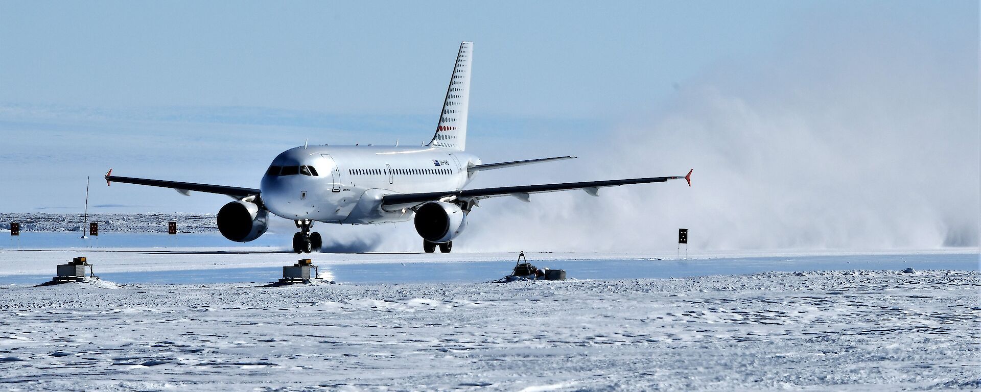 jet plane lands in plume of snow and ice
