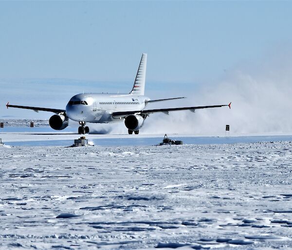 jet plane lands in plume of snow and ice