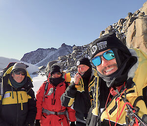 Group of happy men standing near the ice in Antarctica