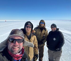 The four man Wilkins team taking a selfie as they standing on the ice runway they have spent so much time creating