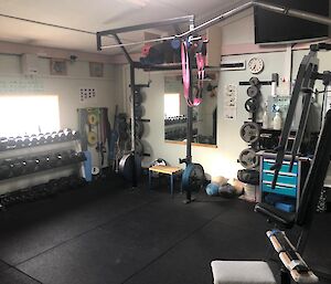 The station gymnasium showing a squat rack and some dumbells