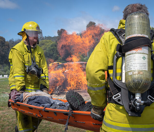 People in protective equipment carry a stretcher