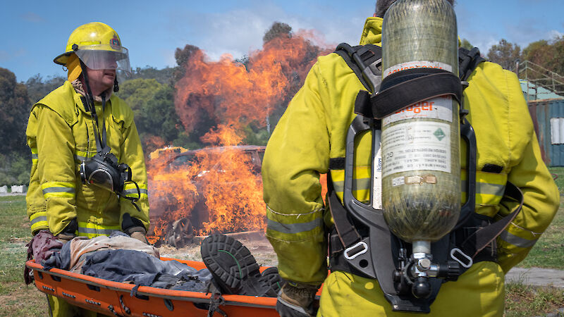 People in protective equipment carry a stretcher