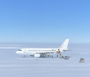 A319 Airbus sitting on the ice runway with support crew surrounding