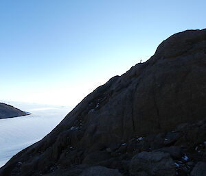 Looking across to the summit of the mountain.  A tiny person is silhouetted against the sky.  Snow and glaciers below.