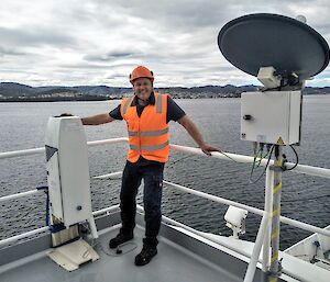 man in hard hat on ship with measuring instrument