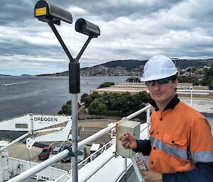 man in hard hat on ship with measuring equipment