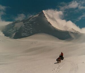 Person on a buggy heading for the snow-covered mountains