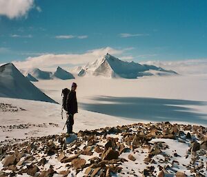 Woman stands alone near Antarctic mountain range