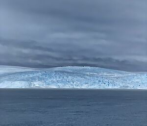 An expanse of sea ice leading to the plateau in the background