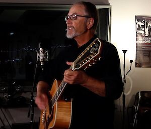 man with guitar in recording studio