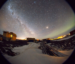 fish eye lens shot of night sky with aurora and stars