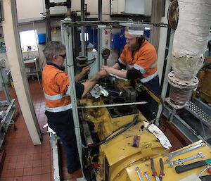 Two diesel mechanics working on some equipment